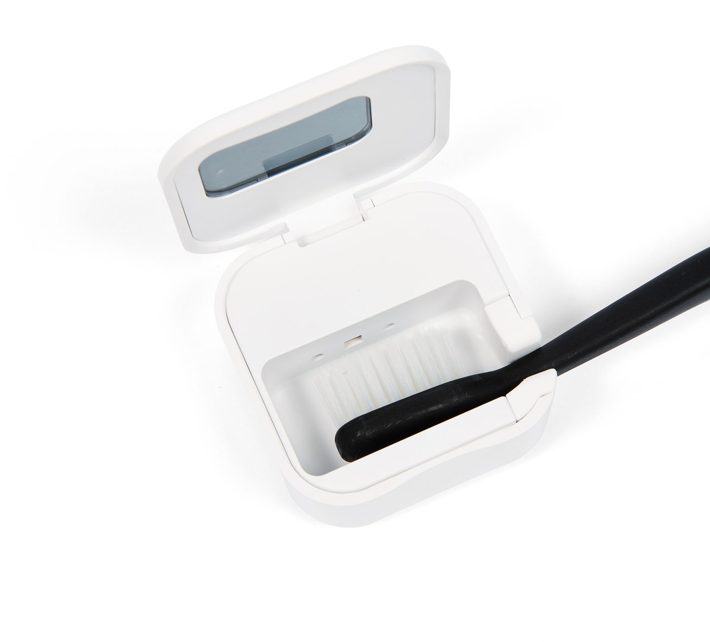 The sanitizer open with a toothbrush seated inside