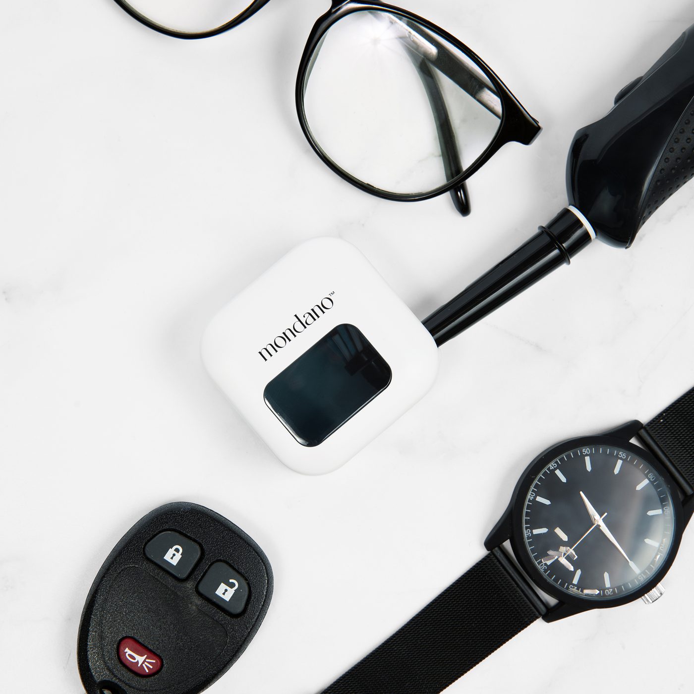 The sanitizer as a travel case beside glasses, a watch and keys